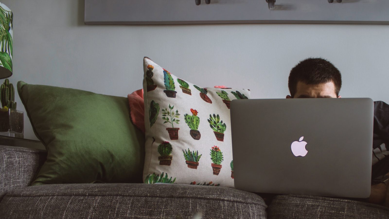 person sitting on couch looking at laptop