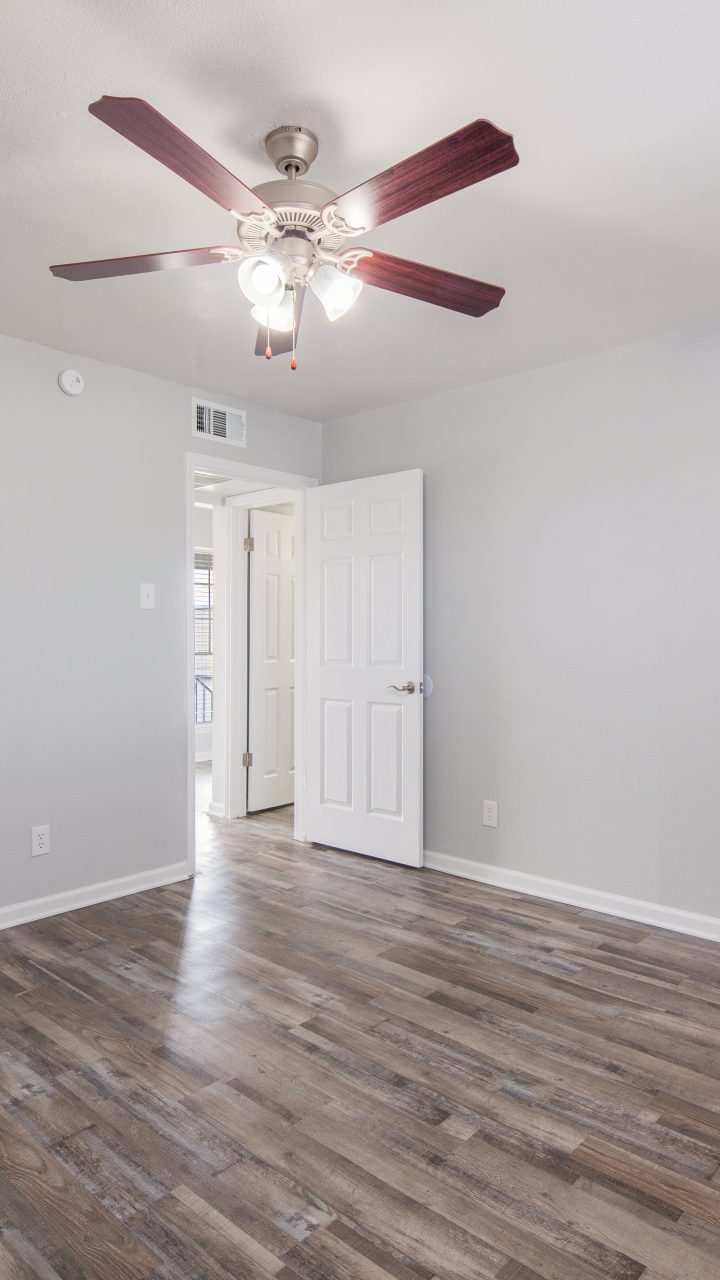 bedroom grey walls brown vinyl plank floors ceiling fan